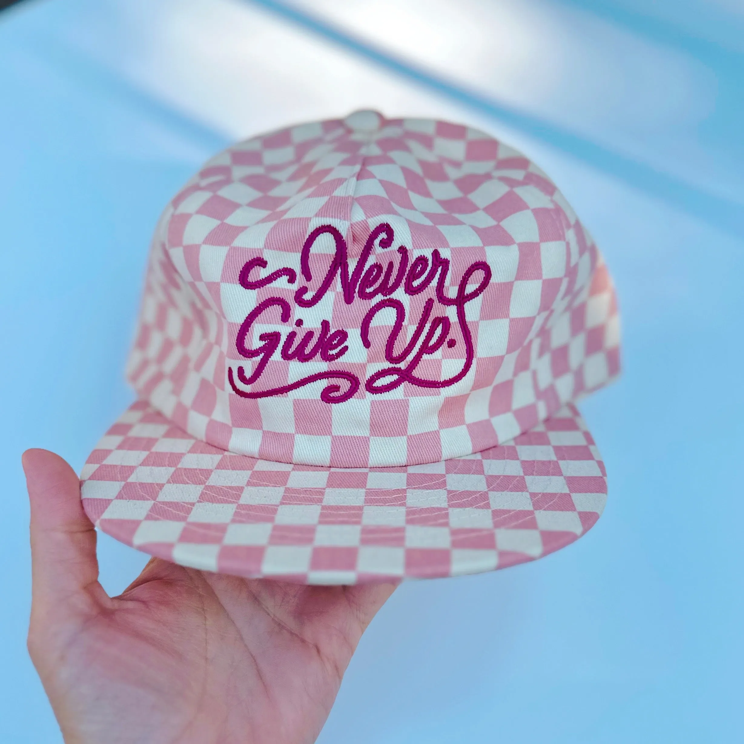 NEVER GIVE UP. PINK CHECKERED HAT