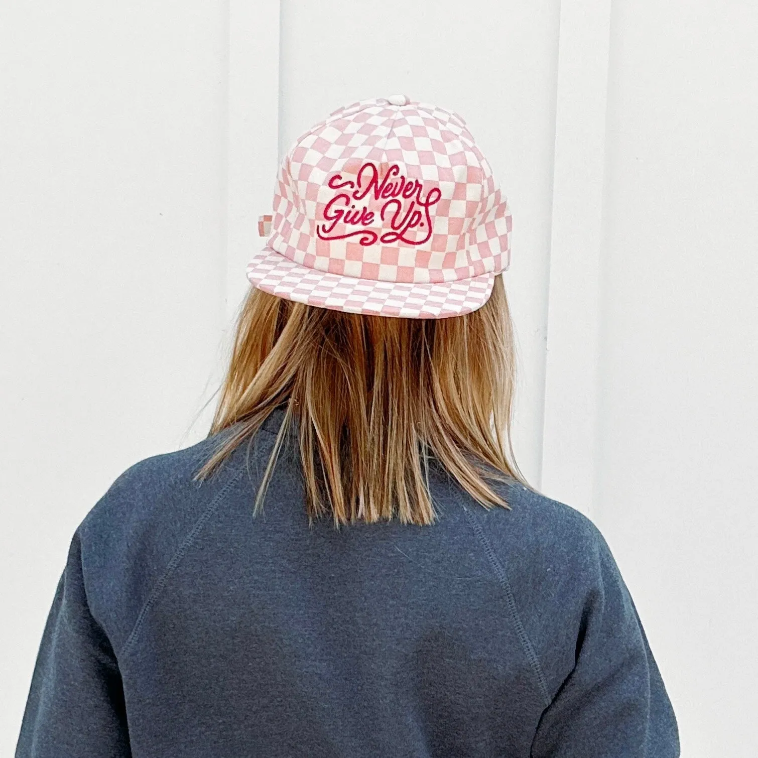 NEVER GIVE UP. PINK CHECKERED HAT